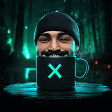 a man with a mustache and beanie is drinking from a black mug with a blue x on it