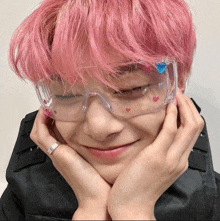 a person with pink hair is wearing a pair of clear glasses with hearts on them