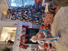 two little girls standing in front of a christmas tree with stockings hanging on the mantle that say santa