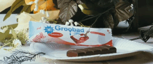 a bar of groobad chocolate sits on a white plate