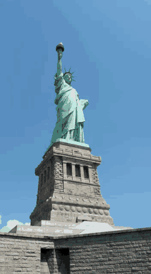 the statue of liberty in new york city stands tall against a blue sky