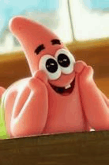 patrick star from spongebob squarepants is smiling while sitting on a table .