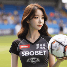 a girl holding a soccer ball wearing a shirt that says sbobet