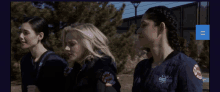 three women wearing chicago fire department uniforms are walking together