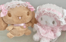 a brown stuffed animal and a pink stuffed animal are sitting next to each other on a table