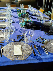 a table set for a dinner party with a blue table cloth