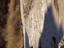 a person is skiing down a frozen waterfall with a pole