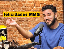 a man in front of a microphone with a yellow sign that says felicidades mming