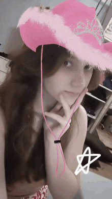 a young girl wearing a pink cowboy hat