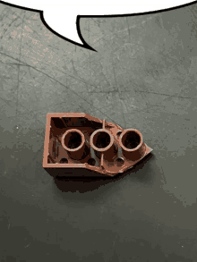 a brown lego block with a speech bubble behind it