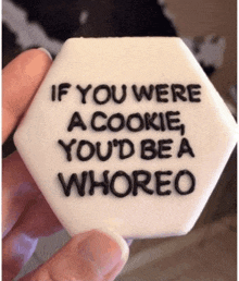 someone is holding a cookie that says " if you were a cookie you 'd be a whoreo "