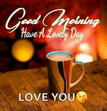 a cup of coffee is on a wooden table with the words good morning have a lovely day love you