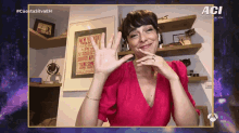 a woman in a red dress is smiling in front of a wall with a poster for the new york theater on it