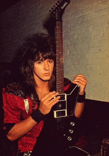 a man playing a guitar with the brand name fender on it