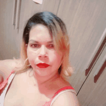 a woman in a red bra takes a selfie in front of a closet