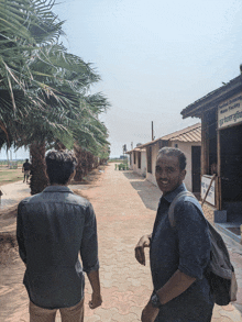 two men walking in front of a building that says ' smoking ' on it