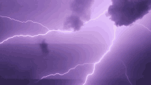 a purple sky with lightning strikes and clouds