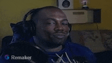 a man wearing headphones is sitting on a couch and smiling .