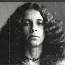 a black and white photo of a woman with long hair and a necklace