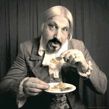 a black and white photo of a man eating a piece of food