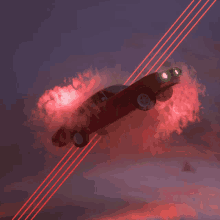 a red car is flying through the air with red smoke coming out of it