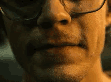 a close up of a man 's face wearing glasses .