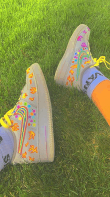 a person wearing a pair of nike shoes with flames and a rainbow on them