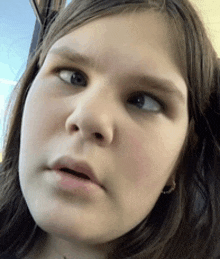 a close up of a young girl 's face with her eyes closed