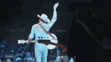 a man in a cowboy hat is playing a guitar in front of a crowd with a sign that says stagecoach