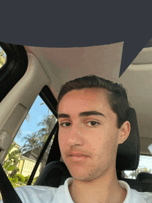 a young man in a white shirt is sitting in a car