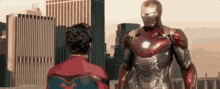 a man in a spiderman suit and a man in a iron man suit are standing next to each other .