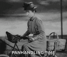 a black and white photo of a woman riding a bicycle with baskets and the words `` panhandling time '' .