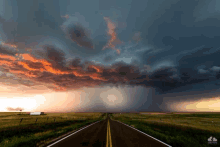 a picture of a road with a storm coming in the distance taken by chris thomas