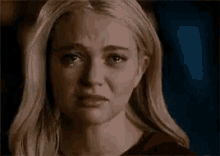 a woman is crying with a tear running down her cheek .