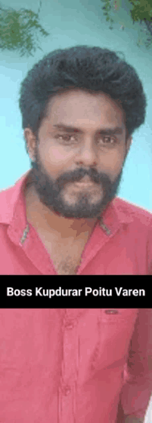 a man with a beard and mustache is wearing a red shirt and has the name boss kupdurar poitu varen on the bottom