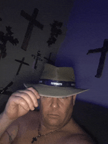 a shirtless man wearing a cowboys hat