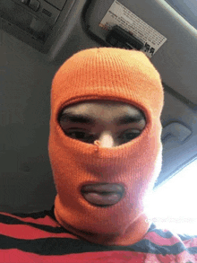 a person wearing an orange ski mask with a sticker on the roof that says ' warning '