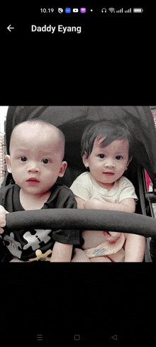 two babies are sitting in a stroller with daddy eyang written on the screen