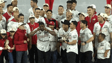 a group of baseball players are posing for a photo and one of them is wearing a shirt that says ' michigan '