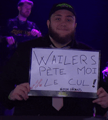 a man with a beard holds up a sign that says wailers pete moi le cul