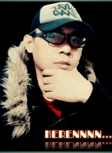 a man wearing glasses and a hat with the name kerennn on the bottom