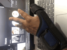 a person wearing a wrist brace is using a laptop with a screen that says home