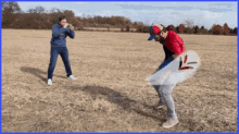 a man in a blue hoodie is taking a picture of another man in a red shirt with the letter l on it