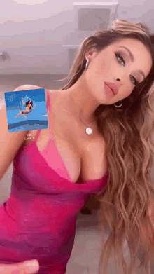 a woman in a pink dress has a picture of a woman on her breast