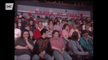 a large group of people are sitting in a stadium with a sign that says ' valentine 's day ' on it