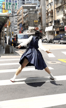 a woman in a blue dress is crossing a street in front of a sign that says 119