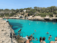 a group of people are swimming in a turquoise water