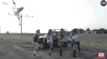 a group of women are dancing in front of a car and a sign that says lovely life on it