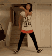 a woman wearing a shirt that says oh ho is dancing in a room