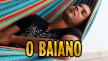 a man laying in a hammock with the words o baiano written above him